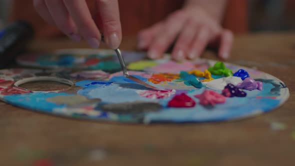 Close Up of Female Artist Hands Mixing Colors on Palette