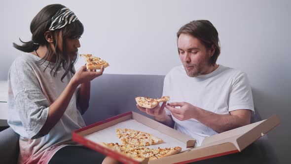 Young Multiracial Couple Eating Pizza From Cardboardbox