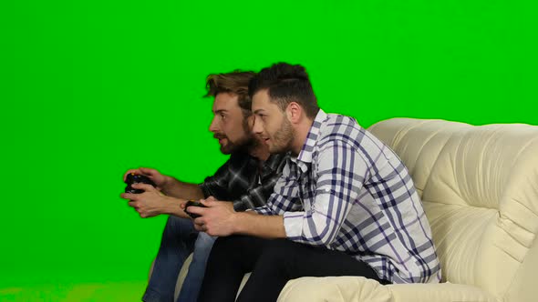 Men Play on the Console in the Same Team. Green Screen