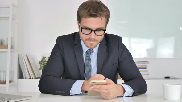 Businessman in Anger Reacting To Loss on Smartphone