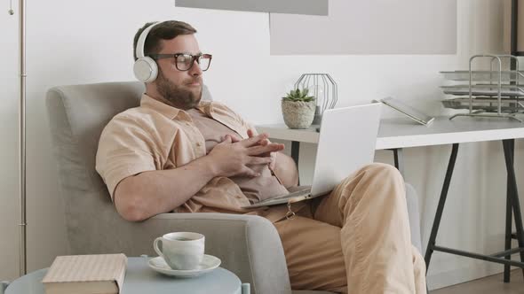 Man Working with Laptop in Armchair