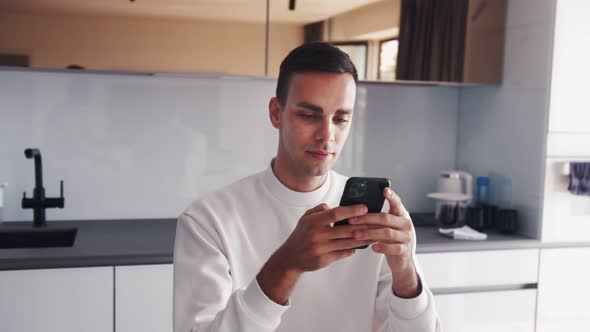 Professional Creative Man Sitting at His Desk in Home Office Studio Using Smartphone, Man Using