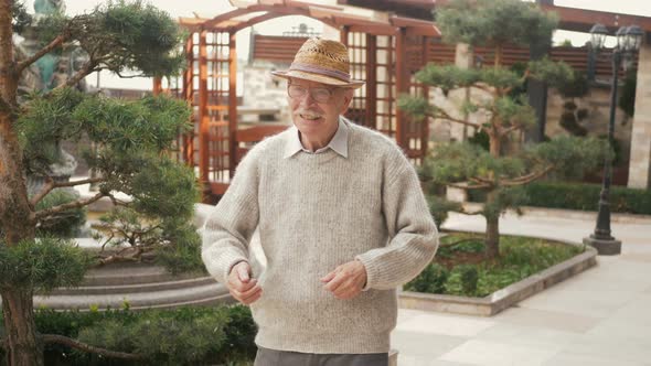 Happy elderly dancer man dancing freestyle in the city