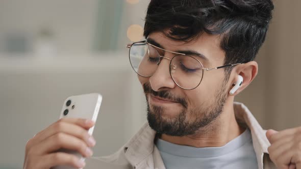 Closeup Arabic Spaniard Man Bearded Guy in Glasses Wears Wireless Modern Headphones Listening to