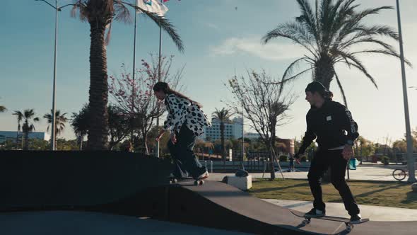 Young Couple Skateboarding at Pump Track or Skate Park on Modern Style