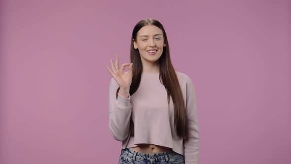 Portrait of a Beauty Model Looking at Camera Making Sign Ok and Smiling