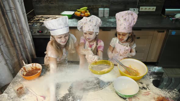 Three girls playing with flour