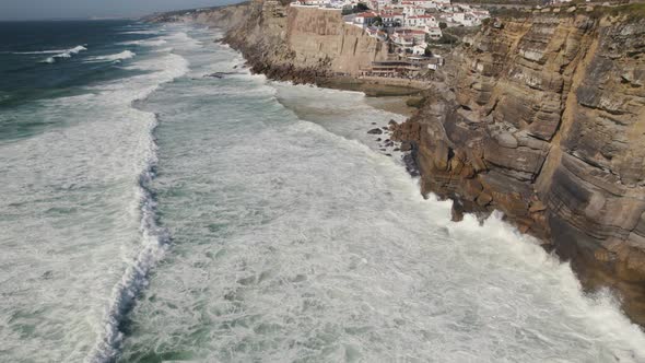 Majestic town of Azenhas Do Mar on rocky cliff side in Portugal, sea hitting coast