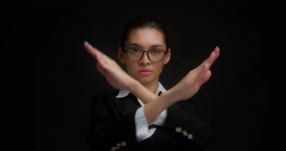Angry Young Woman Holds Her Crossed Arms in an x Gesture and Looks at the Camera