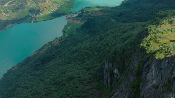 Lush Forest Trees Downhill Of Klovane Summit Near Olden Village In Norway. - Aerial Pullback Shot