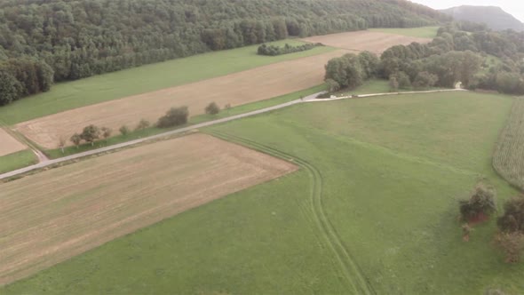 Aerial shot of fields, a road and a forest in the background. Super wide shot of a landscape in Germ