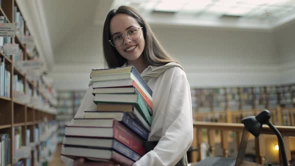 Smiling Student with Books Stack in Hands