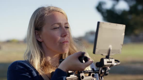 Female Film Maker Watching Monitor And Tilting Camera