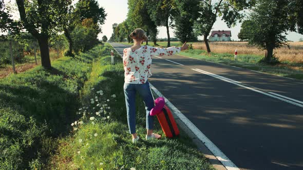 Young Woman Hitchhiking on Countryside Road