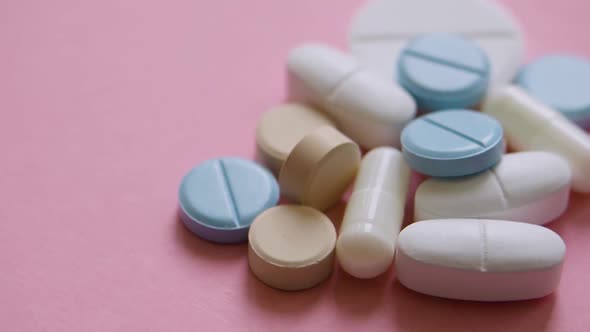 Top View Rotation  Pills and Capsules on a Pink Background Closeup