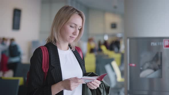 An Attractive Young Woman at the Airport is Waiting for Her Departure