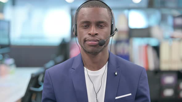 Portrait of African Businessman with Headset Looking at Camera