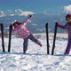 Little Girls in Outwear and Helmets Posing with Skis on Snow with Mountain Range on Background - VideoHive Item for Sale