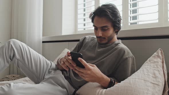 Man Scrolling Feed on Smartphone