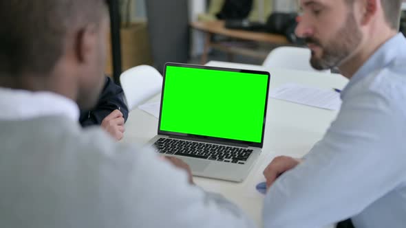 Rear View of Male and Female Business Person Using Laptop with Green Chroma Screen