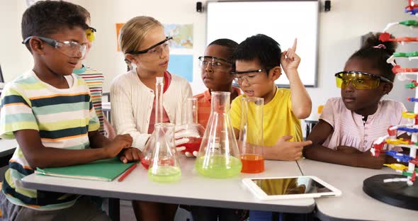 School kids doing chemical experiment in classroom