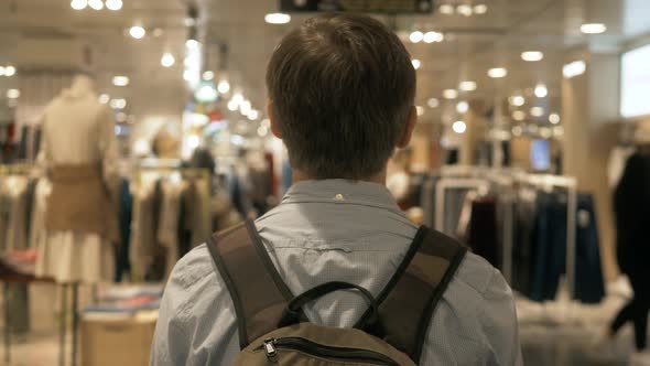 At the Supermarket Shopping Mall: Man Walking with Backpack in Store. Store with Many Customers