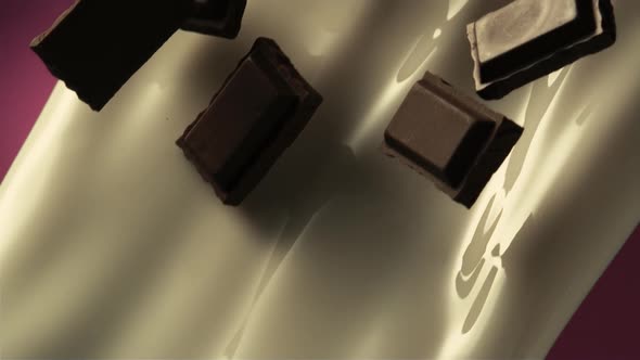 Chocolate pieces blend with pouring milk in slow motion.8