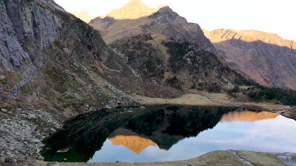 Lac d'Espingo lake  reflecting nearby peaks with calm water in Haute-Garonne, Pyrénées mountains, Fr