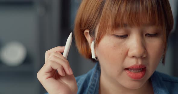 Asia businesswoman using tablet talk to colleagues about plan in video call while working.