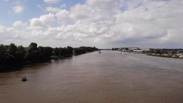 Aerial Above Along River Noord With Ships In The Background. Dolly Forward