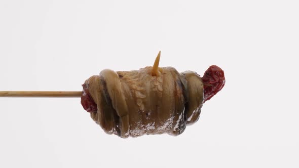 Vertical video: Canned eggplant on a stick rotates