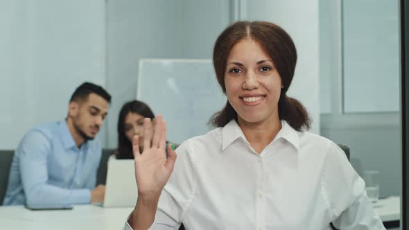 Portrait Smiling Businesswoman Sitting in Modern Business Office with Multicultural Professionals
