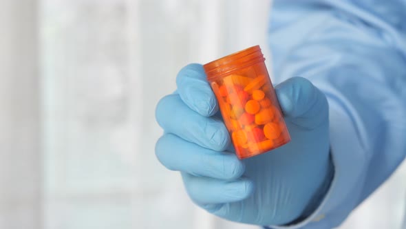 Doctor Hand in Protective Glass Holding Pill Container 