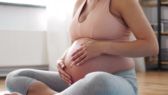 Happy Pregnant Woman Touching Her Belly at Home