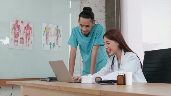 Two uniformed young doctors work in medical clinic office.