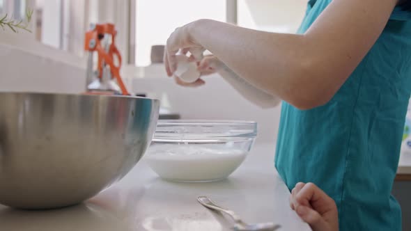 Girl preparing and mixing ingredients for pancakes in the kitchen