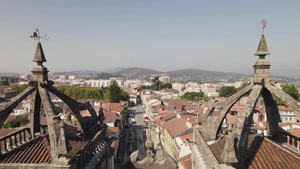 Aerial flying backwards between Braga Cathedral towers reveal Historic Location