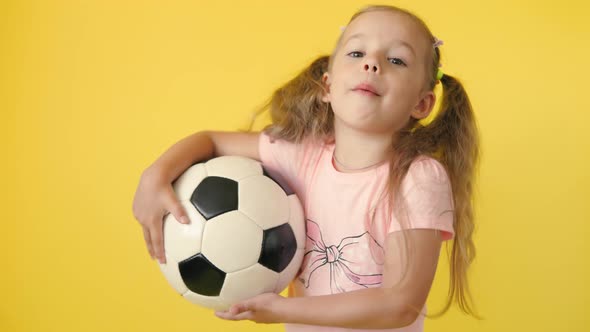 Authentic Cute Smiling Preschool Little Girl with Classic Black and White Soccer Ball Look at Camera