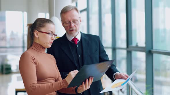 Young secretary talking to a senior businessman