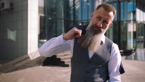 Portrait of Handsome Bearded Mature Man in Suit Outdoors on Modern Building Background During Sunny