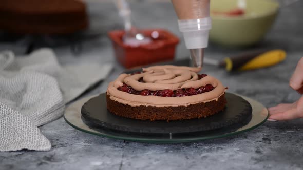 Close Up of Woman Hands Making Sweet Cherry Cake with Chocolate Cream and Biscuit.