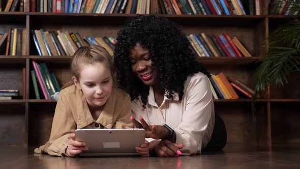 Black Lady Talks to Schoolgirl with Tablet and Shows Photos