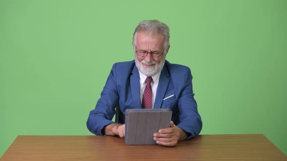 Handsome Senior Bearded Businessman Against Green Background