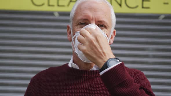 Caucasian man out and about in the street wearing on a face mask against coronavirus