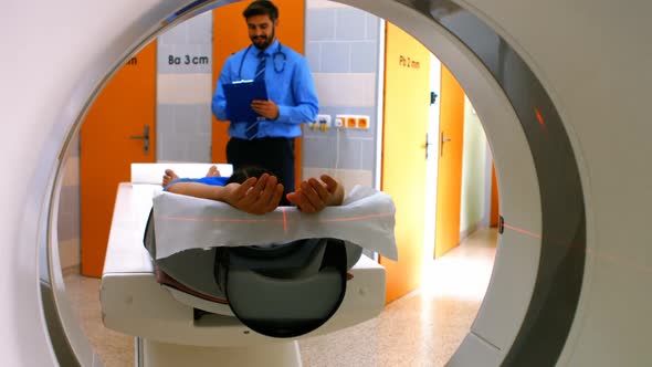 Doctor reviewing chart of patient about to have mri scan