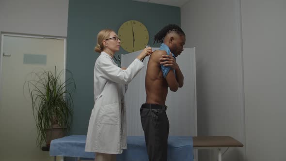 Skilled Doctor Checking Male Patient By Using Stethoscope on Man Back