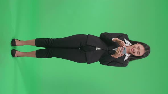 Full Body Of Asian Business Woman Raising Index Finger While Using Mobile Phone In The Green Screen