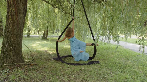 Girl in Blue Dress Hanging on Aerial Silk