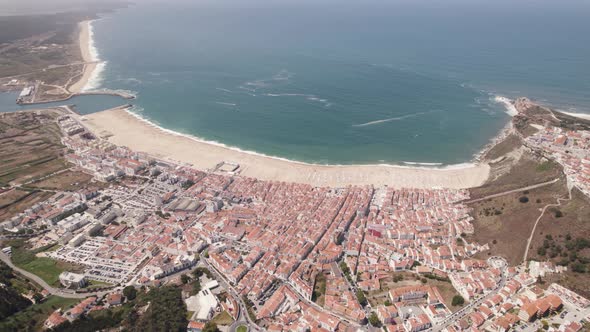 Wide aerial drone view of Nazare gulf and cityscape, Portugal