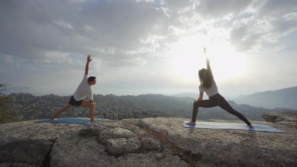 Couple practicing yoga in mountains